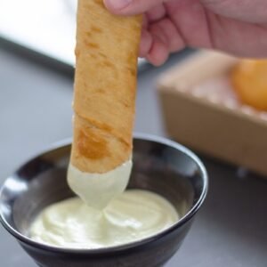 person holding bread with white cream
