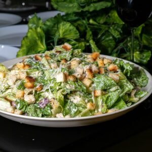 Delicious caesar salad is presented on a table.