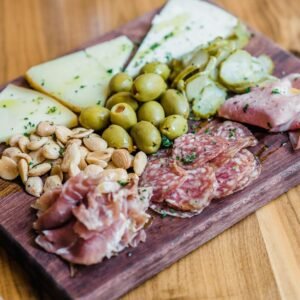 sliced meat with green vegetable on brown wooden chopping board